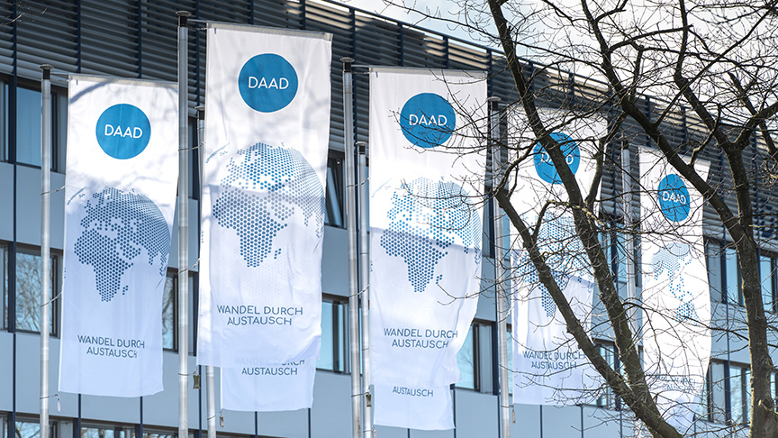 Flags with DAAD logo in front of the outer facade of the headquarters in Bonn.